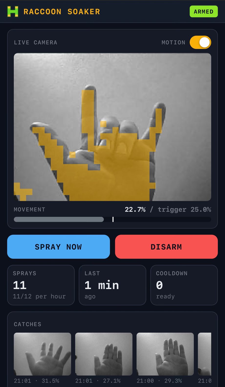 The app on my iPhone: ARMED, the live camera with my hand making devil horns under amber motion blocks, movement 22.7 % against a 25 % trigger, Spray now and Disarm, 11 sprays, and a strip of catches showing my hand