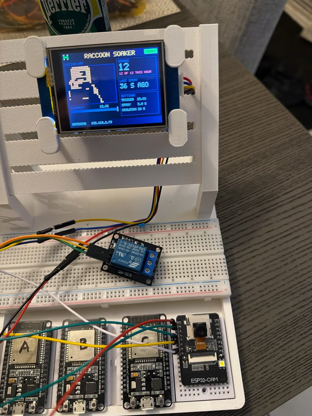 The rig: the Nextion on the panel, the relay on the hub breadboard, ESP32 boards A, B and C, and the ESP32-CAM in the dock with jumpers to the hub