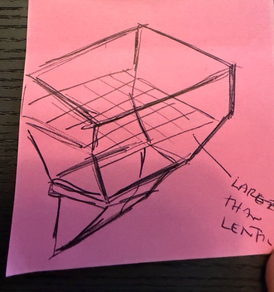 A pencil sketch on a pink sticky note: an open box with a grid partway down, the bottom narrowing to a chute, and a note pointing at the grid: "larger than lentils"